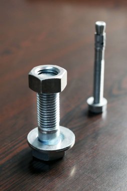 Cıvata, fındık ve çamaşır makinesinin görüntüsü. Cıvatalar, bir fındık yardımıyla iki başlıksız bileşenin montajı içindir. Kontrastlı vidalar kendi ipliklerini içeren bileşenlerde kullanılır.