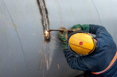 İşçi manuel alev kesme işlemi ile metal plakaya kesiyor. Oxy yakıt kaynaklama, oksiasetilen kaynaklama, oksikodon kaynaklama veya gaz kaynaklama ve oksi yakıt kesme yakıt gazı kullanan süreçlerdir..