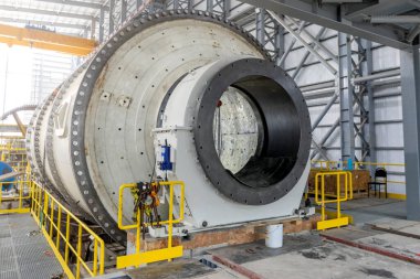 View of industrial ball mill. A ball mill is a type of grinder used to grind or blend materials for use in mineral dressing processes, paints, pyrotechnics, ceramics, and selective laser sintering.