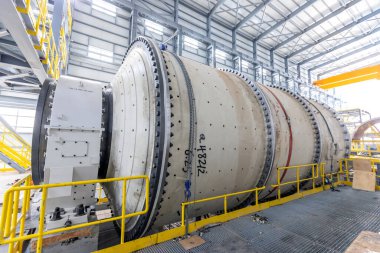 View of industrial ball mill. A ball mill is a type of grinder used to grind or blend materials for use in mineral dressing processes, paints, pyrotechnics, ceramics, and selective laser sintering.