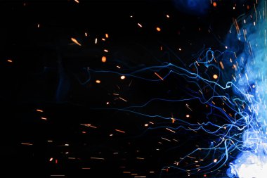 Gaz metal kaynaklama (GMAW) işleminin arka plan ve görüntüsünü kıvılcımlar, ışık, bokeh etkisi ve duman ile kapatın. Kıvılcımların soyut arkaplanı