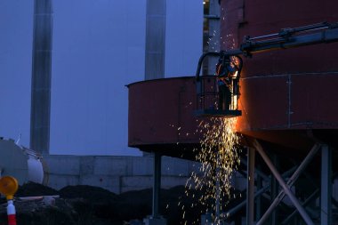 Kaynakçı inşaat alanındaki daha kalın tanklarda kaynak ve öğütme yapıyor (Seriler-1).