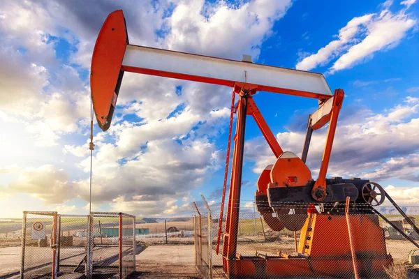 油に油を注いでいる 油田の油井にポンプジャック アレンジメントは 一般的に小さな油を生産する陸上井戸に使用されます それはオイル井戸の互換性があるピストン ポンプのための地上ドライブです — ストック写真