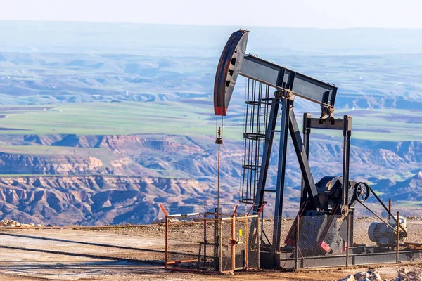 山の石油ポンプ 油田の油井にポンプジャック アレンジメントは 一般的に小さな油を生産する陸上井戸に使用されます それはオイル井戸の互換性があるピストン ポンプのための地上ドライブです — ストック写真