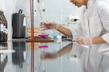 Laboratuvar teknisyeni bilimsel ve kimyasal deneyler yapıyor. Kimya teknisyenlerini çalıştıran endüstriler arasında kimyasal, petrokimya ve ilaç endüstrisi yer alıyor. Laboratuvarda çalışan Asyalı bilim adamı.