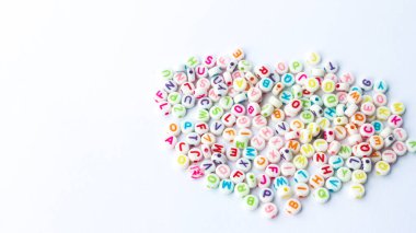 Collection of colourful beads blocks to make handmade jewellery bracelet names. heap of multi colored beads in street shop. Alphabets in kinder garden school for kids.