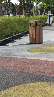 Gün boyunca şehir parkında kahverengi demir çöp tenekesi. Şehir parkını temiz tutmak..