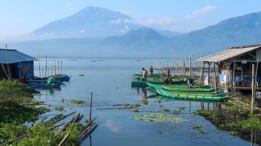 Semarang, 11 Mart 2023 - Rawa Pening Gölü kıyısında balıkçı tekneleri. Rawa Pening Gölü 'nün, Merbabu' nun ve Telomoyo dağlarının güzel manzarası. Rawa Gölü 'ndeki balıkçılar..