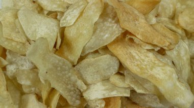 Bir kase tatlı taro kızartması ya da kare desenli peçete ve beyaz arka planda Keripik Talas. Geleneksel Endonezya yemeği. Seçici Odaklanma.