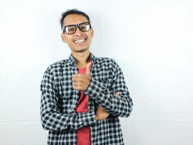 Beyaz arka planda izole edilmiş iyi niyet gösteren neşeli Asyalı genç bir adamın portresi. Anlaştık, onaylandı. Tamam, Thumps up