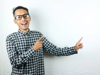 Gülümseyen Asyalı adam boş bir içerik sunumunu işaret ediyor. Reklam modeli konsepti.