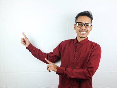 Gülümseyen Asyalı adam boş bir içerik sunumunu işaret ediyor. Reklam modeli konsepti.