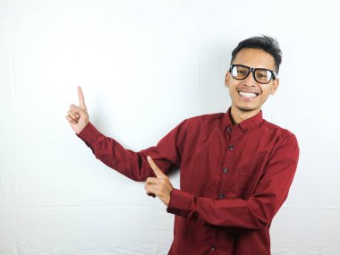 Gülümseyen Asyalı adam boş bir içerik sunumunu işaret ediyor. Reklam modeli konsepti.