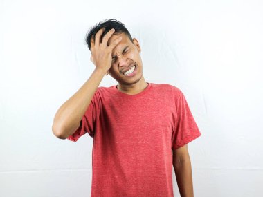 Asyalı insanlar üzgün ve baş ağrısından dolayı ellerini sıkarak başlarını sıkıyorlar. Stres ve migren kavramı.