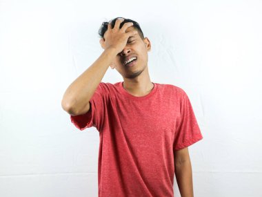 Asyalı insanlar üzgün ve baş ağrısından dolayı ellerini sıkarak başlarını sıkıyorlar. Stres ve migren kavramı.