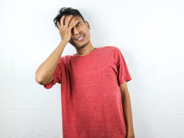 Esnemiş yüz ifadesi, uykulu ve beyaz arka planda sırt ağrısı olan yorgun Asyalı bir adam.