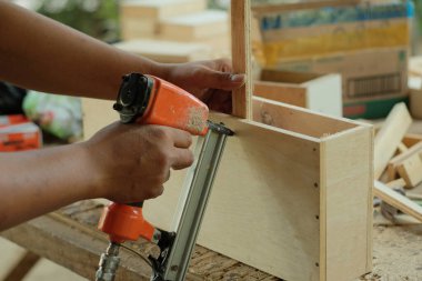 Marangoz atölyede ahşabı ölçüyor, kesiyor, zımparalıyor