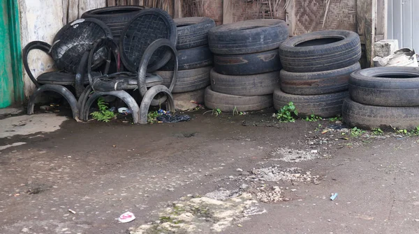 Pile of old tires and wheels for recycling rubber. tire patch on the side of the road.