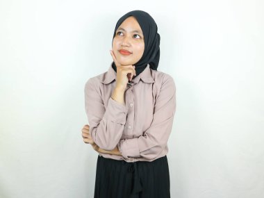 Asyalı genç bir kadının portresi yukarı bakıyor ve çenesine dokunuyor.