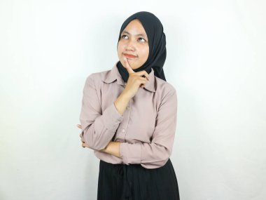 Asyalı genç bir kadının portresi yukarı bakıyor ve çenesine dokunuyor.