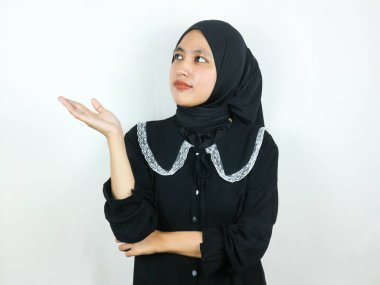 Neşeli, Asyalı, tesettürlü, güzel Müslüman kadın. Palmiye ve Reklamcılık konseptinde kopya alanı sunuyor.