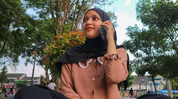 Portrait of Arab business woman on the mobile phone in a park