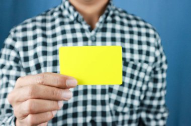 Çekici bir iş adamı elinde boş sarı kartlar tutuyor..