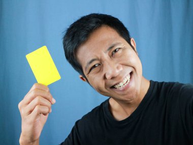 Asyalı adamın mavi arka planda boş kart tutması komik bir yüz ifadesi. Aktarım konsepti