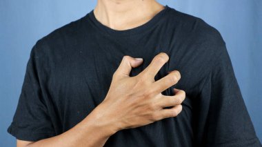 Kalp krizi. Akut ağrıdan göğsünü tutan bir adam. Kalp krizi belirtileri. Şiddetli kalp ağrısı, göğüs ağrısı çeken bir adam, kalp krizi ya da acı veren kramplar, göğsüne bastıran bir adam.