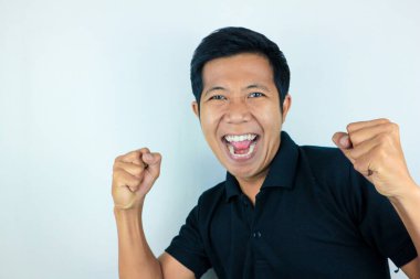 Evet, yumruklarını sıkan Asyalı adamın mutlu ifadesi. Zafer kavramı, izole edilmiş beyaz arkaplan