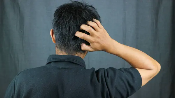 back view of a man scratching his head because it itches. dandruff problem concept