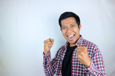 Evet, yumruklarını sıkan Asyalı adamın mutlu ifadesi. Zafer kavramı, izole edilmiş beyaz arkaplan