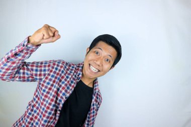 Evet, yumruklarını sıkan Asyalı adamın mutlu ifadesi. Zafer kavramı, izole edilmiş beyaz arkaplan