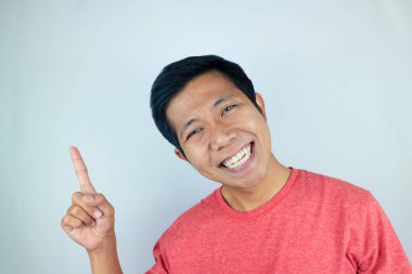 Ürünü sunan tarafı gösterirken gülümseyen Asyalı adam ifadesi. reklam kavramı