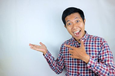 Ürünü sunan tarafı gösterirken gülümseyen Asyalı adam ifadesi. reklam kavramı