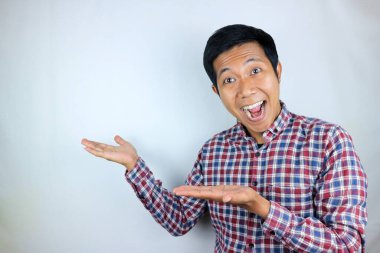 Ürünü sunan tarafı gösterirken gülümseyen Asyalı adam ifadesi. reklam kavramı