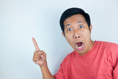 Asyalı adamın komik yüz ifadesi. Sağ tarafı gösterirken şok olmuş ve şaşırmış.