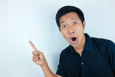 Asyalı adamın komik yüz ifadesi. Sağ tarafı gösterirken şok olmuş ve şaşırmış.