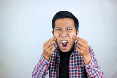 Asyalı adamın sinirli ifadesi yanağına dokunuyor çünkü tombul.