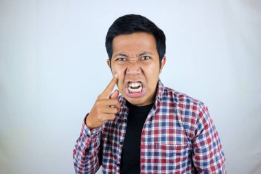 Asyalı adamın sinirli ifadesi yanağına dokunuyor çünkü tombul.