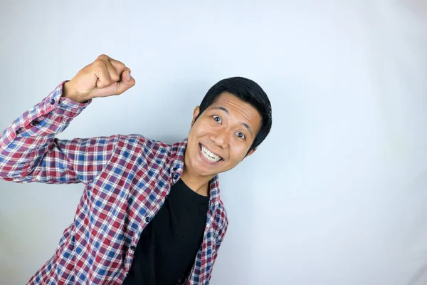 Evet, yumruklarını sıkan Asyalı adamın mutlu ifadesi. Zafer kavramı, izole edilmiş beyaz arkaplan