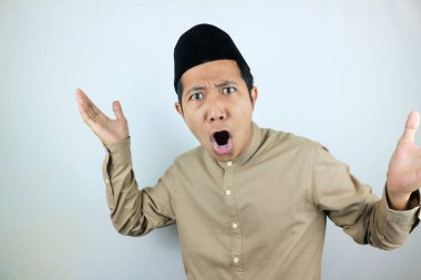 Komik yüz ifadesi şoku ve kafası karışmış Asyalı Müslüman erkekler beyaz arka planda izole edilmiş kep takıyor.