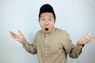 Asyalı Müslüman erkeklerin beyaz arka planda yalıtılmış şapkalar giymesi komik ve sürpriz bir ifade.