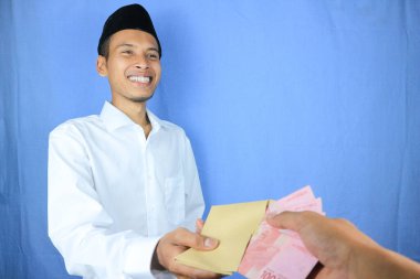 Asyalı Müslüman bir adamın yardım, bağış veya sadaka için para verdiğinin gülen ifadesi