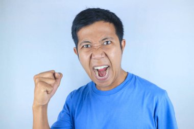 Asyalı adamın kızgın yüz ifadesi güçlü el hareketleri yaparken, beyaz arka planda izole edilmiş.