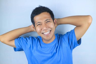 Gülümseyen yüz ifadesi genç Asyalı adam kameraya bakarken mutlu, beyaz arka planda soyutlanmış.