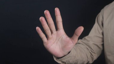 Beş parmaklı iş adamı el hareketi, siyah arka planda izole edilmiş.