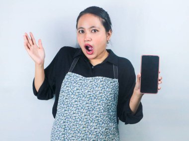 Şaşırtıcı bir ifade Asyalı garson cep telefonunu boş ekran ile tutuyor. Kopya alanı oluştur