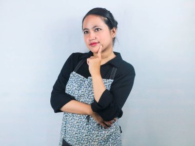 Genç Asyalı kadın solüsyon arayan garsonlar ya da önlüklü barista sağ üst köşeye bakıyor.