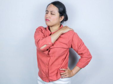 Uzun bir iş gününden sonra omuzları ve sırt ağrısı çeken genç ve güzel Asyalı iş kadını. çok çalışılmış, beyaz arkaplanda izole edilmiş